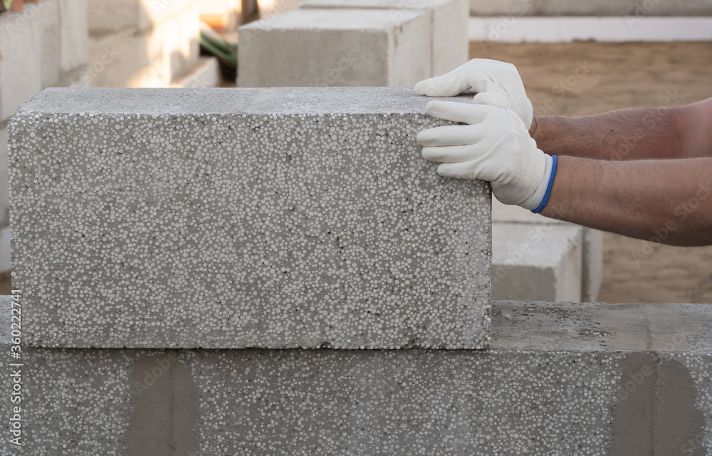 man lays stone blocks, building a house. copy space. man lays stone blocks, building a house. copy space.