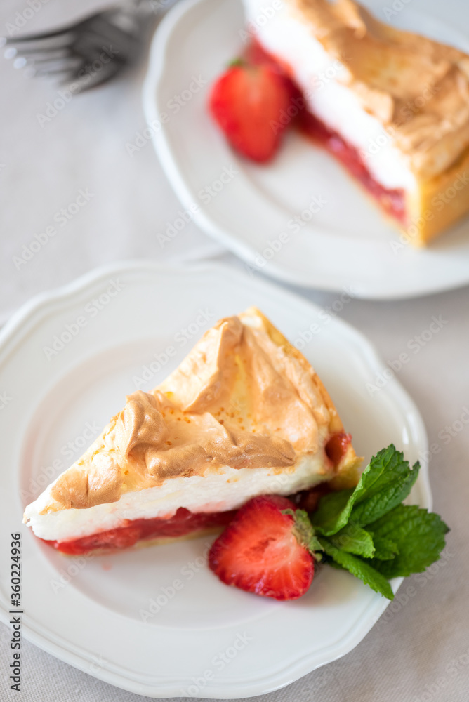 Slice of delicious strawberry tart with meringue on wooden background. Summer food Slice of delicious strawberry tart with meringue on wooden background. Summer food