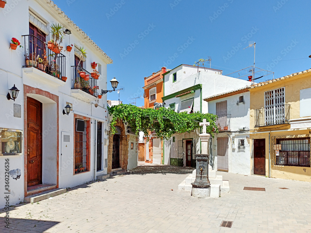 Pretty charming houses decorated with flowerpots ivy leaves in empty small square of Denia old town, spanish historical coastal city in province of Alicante Costa Blanca. Spain