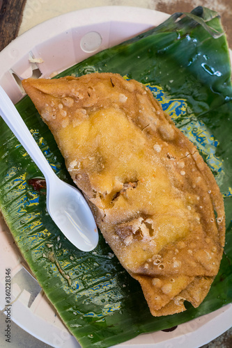 Top view of freshly cooked and authentic Ilocos Empanada on pandan leaves. photo