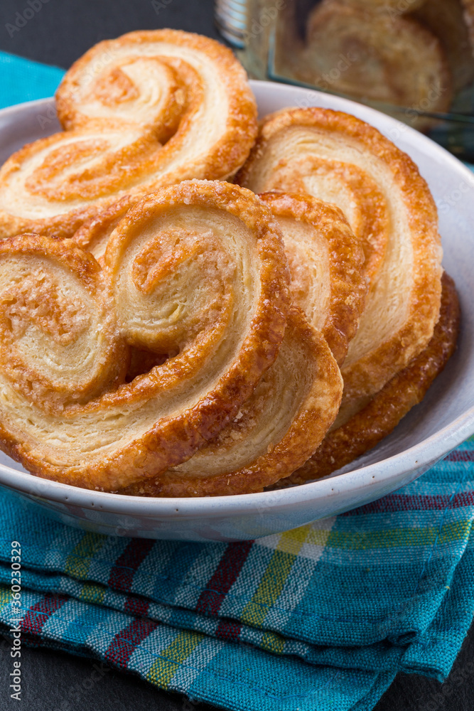 Palmier biscuits on a plate over a fabric napkin Palmier biscuits on a plate over a fabric napkin