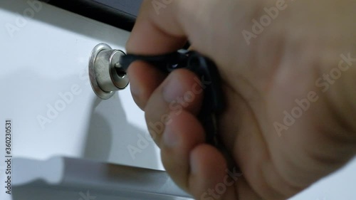 Using a key to open the lock of the drawer. Unlock door.
