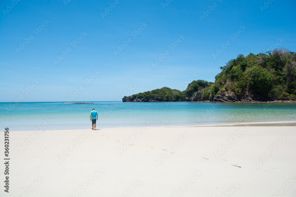 man walking on beautiful beach and tropical sea at lipe island ,satun Thailand