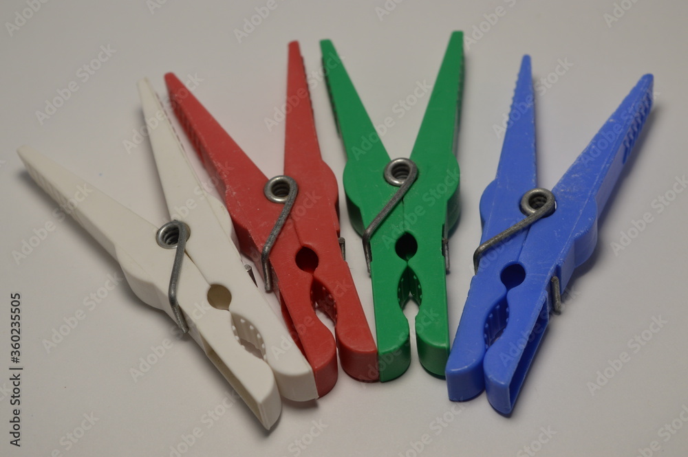 A lot of colored plastic clothespins on a white background A lot of colored plastic clothespins on a white background