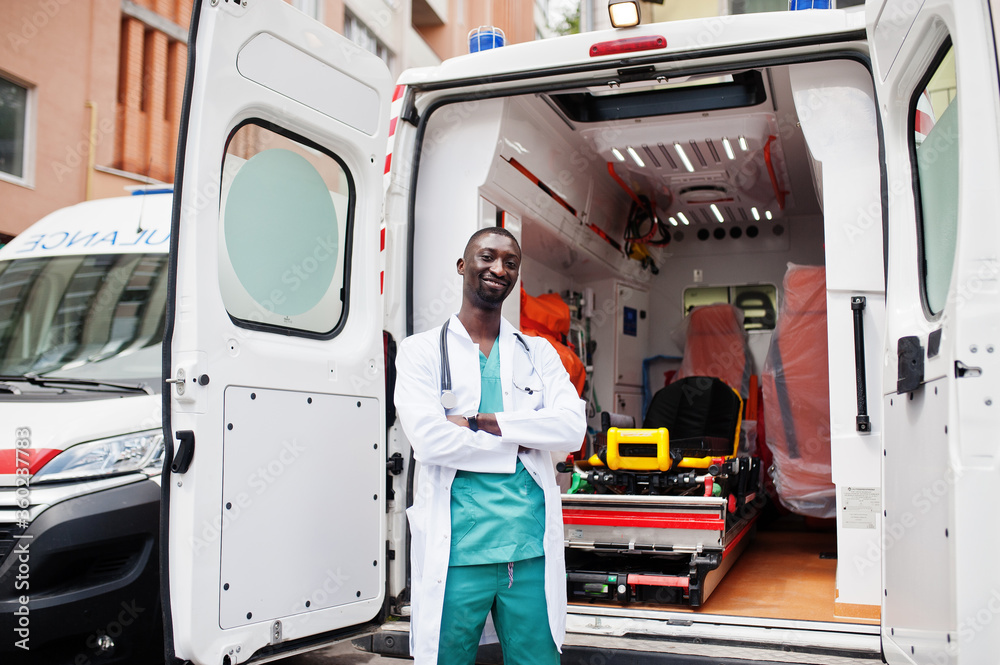African male paramedic standing in front of ambulance car. African male paramedic standing in front of ambulance car.