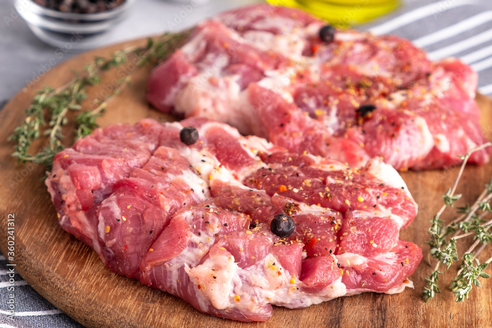 Raw pork meat pieces on a wooden board.