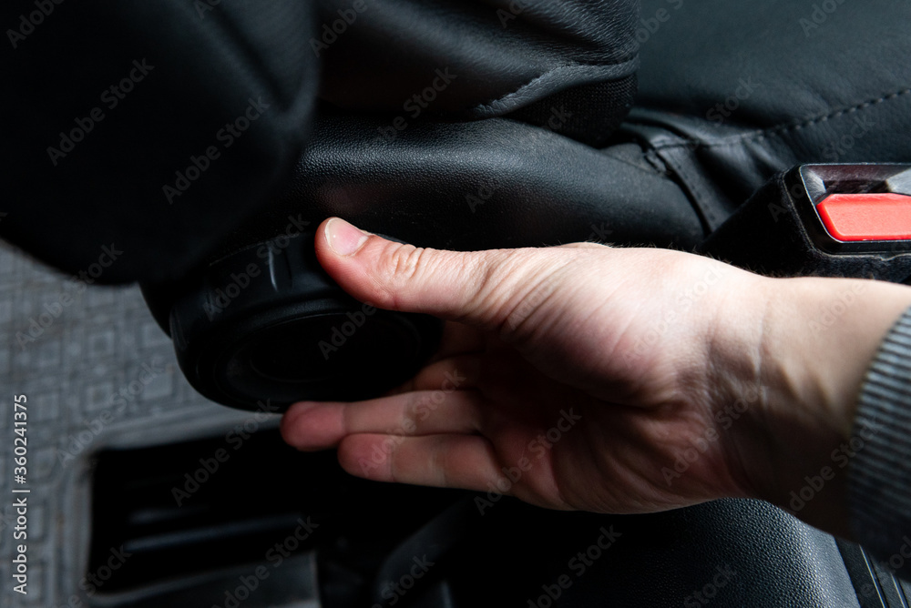 Hand holding on lever for adjustable car seat. Hand holding on lever for adjustable car seat.