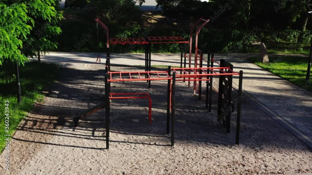 Aerial view. Gym with a swing outside in a city park on a summer morning. Complex for workout among green trees and grass. Sport and healthy lifestyle Aerial view. Gym with a swing outside in a city park on a summer morning. Complex for workout among green trees and grass. Sport and healthy lifestyle