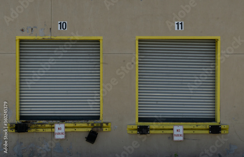 Two closed loading dock doors for semi trailer stucks empty parking lot