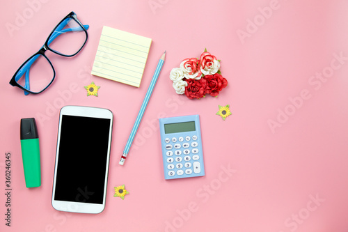 Yellow notebook mobile phone calculator and hilight marker blue glasses on pink background pastel style with copyspace flatlay clipping path on screen moblie