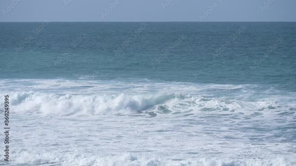 Sandy sea shore in bright sunny day with. Sparkling waves lapping on the beach and form a white foam. Sandy sea shore in bright sunny day with. Sparkling waves lapping on the beach and form a white foam.