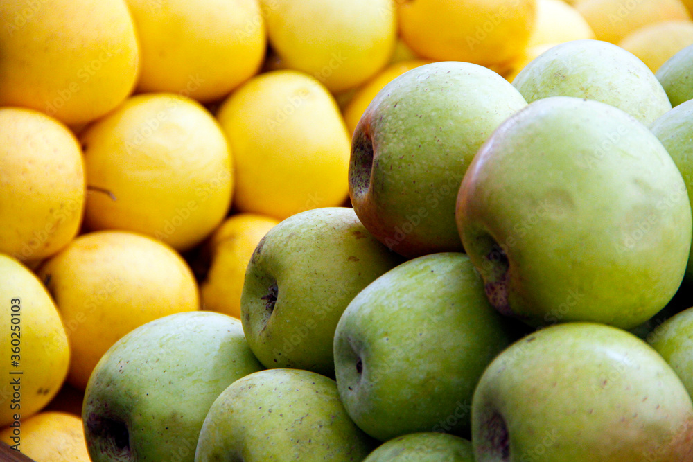 Green and yellow apples in the stock