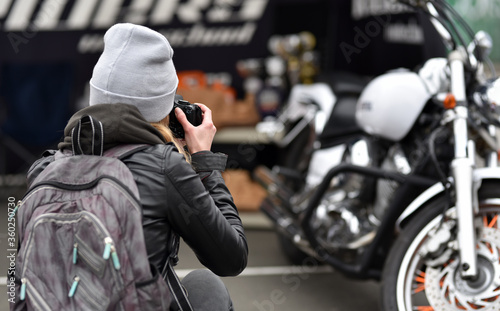 woman photographer is shooting motorbike on exhibition