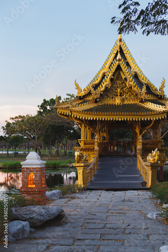 MUEANG BORAN, ANCIENT SIAM (ANCIENT CITY), SAMUT PRAKAN PROVINCE, BANGKOK, THAILAND - March 19, 2017 : Golden bridge and pavilion of the Enlightened at sunset, historical park museum Muang Boran