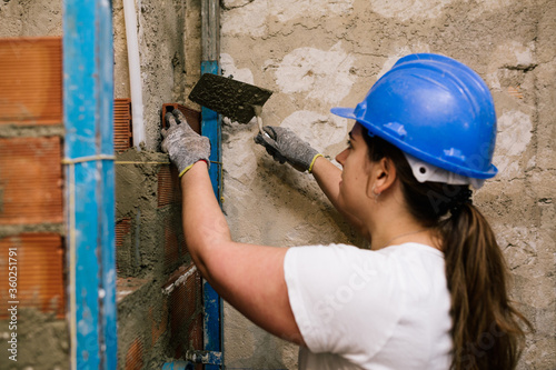 woman working with a spatula in the construction of a wall