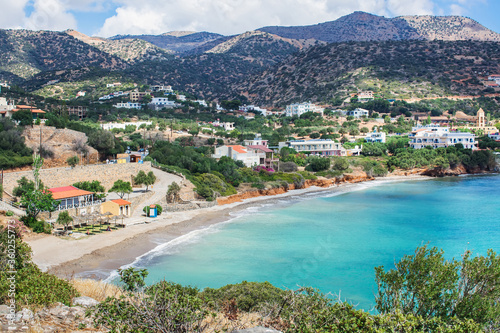Coast of a greek island in the mediterranean sea. A bay with beautiful blue clear water, with a beach, on a background of mountains.