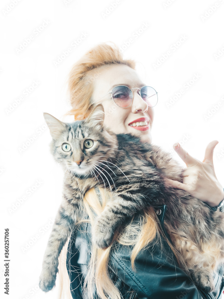Beautiful blonde in sunglasses holds a large striped cat on a bright white background. High key