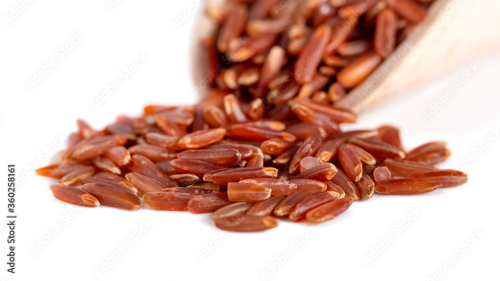 Red rice on wooden spoon isolated on a white background Red rice on wooden spoon isolated on a white background