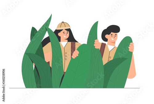 Explorers, travelers in the jungle large green leaves. Man and woman enjoy a picturesque landscape of plants. Concept of discovery, exploration, hiking, adventure tourism and travel.