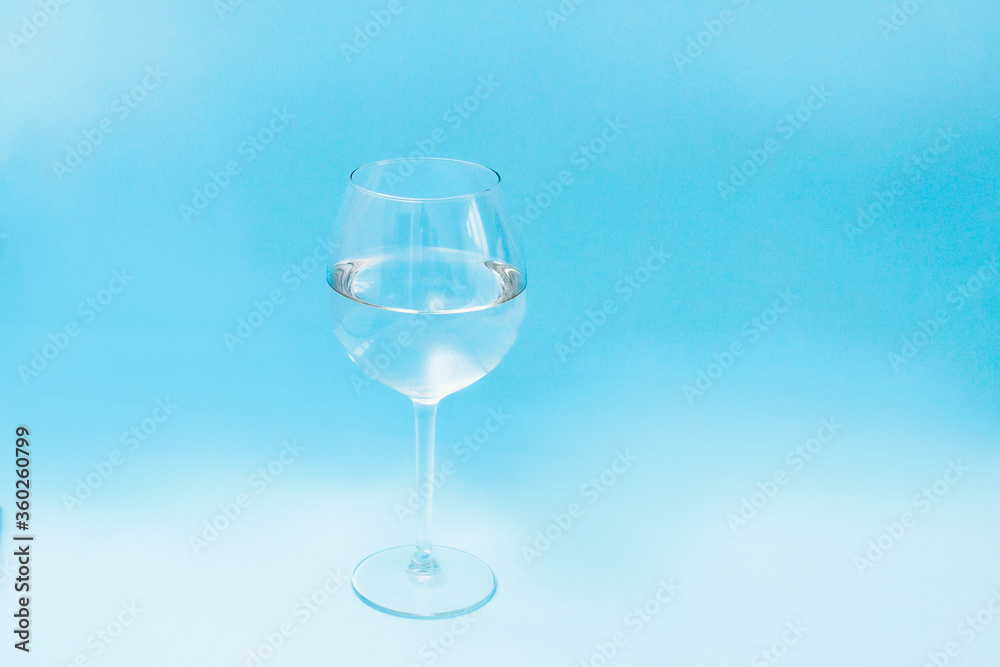 glass wine glass filled with water on a blue background, front view glass wine glass filled with water on a blue background, front view