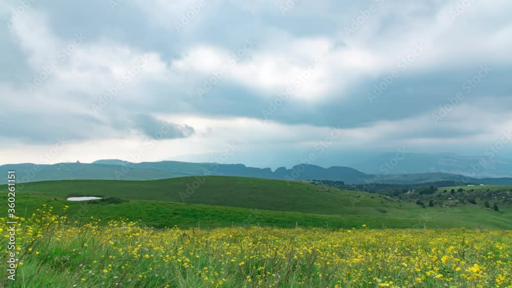 This stock video shows a time-lapse pan across the Lessinia mountain group in the Veneto Prealps with green meadows and ponds, in Italy. This stock video shows a time-lapse pan across the Lessinia mountain group in the Veneto Prealps with green meadows and ponds, in Italy.