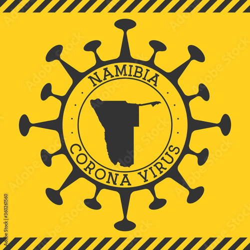 Corona virus in Namibia sign. Round badge with shape of virus and Namibia map. Yellow country epidemic lockdown stamp. Vector illustration.