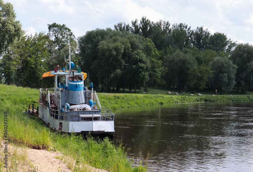 old boat on the river bank on a sunny summer day. old boat on the river bank on a sunny summer day.
