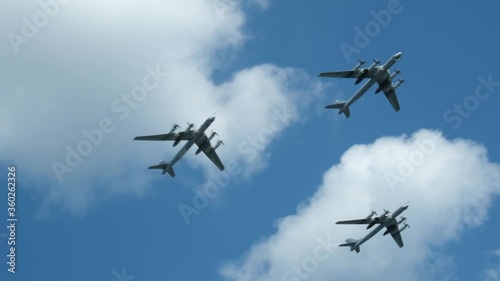 Column military warplanes flies over the ground in honor of the victory parade . Military planes in a beautiful blue sky. Air force parade.