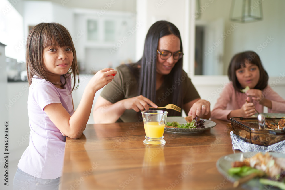 Mother and daughters eating lunch at table Mother and daughters eating lunch at table
