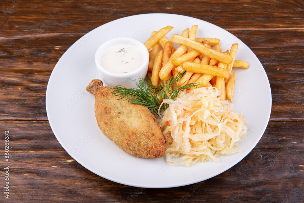 Chicken cutlet with french fries, sauerkraut and sauce