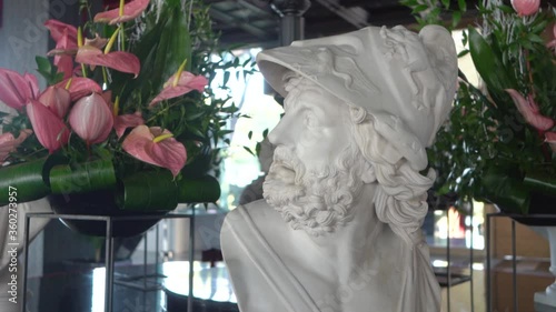 Beautiful decoration of white statue in the background of flowers. Interior design in details