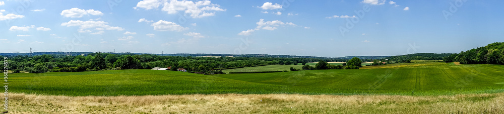 A panoramic view of The Berkshire Countryside as seem from Nuntide Hill in Reading, UK. Blue sky and green fields