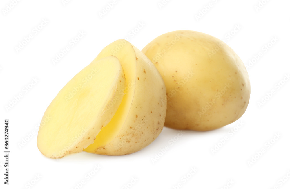 Whole and cut fresh raw organic potatoes on white background