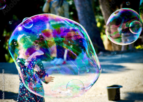 multicoloured big soap bubbles street artist in park Guell Barcellona