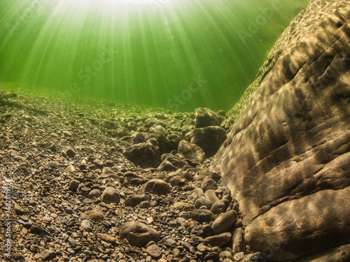 Underwater scenery in river Maggia / Switzerland / Europe with magical sun beams