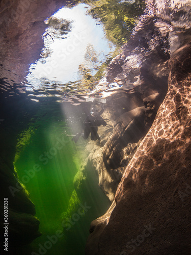 Underwater scenery in river Maggia / Switzerland / Europe with snorkeler and magical sun beams