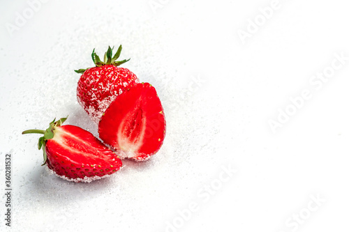 The berries of a ripe tasty strawberry lie on sugar. Summer berries. Background with strawberries. Free space in the photo.