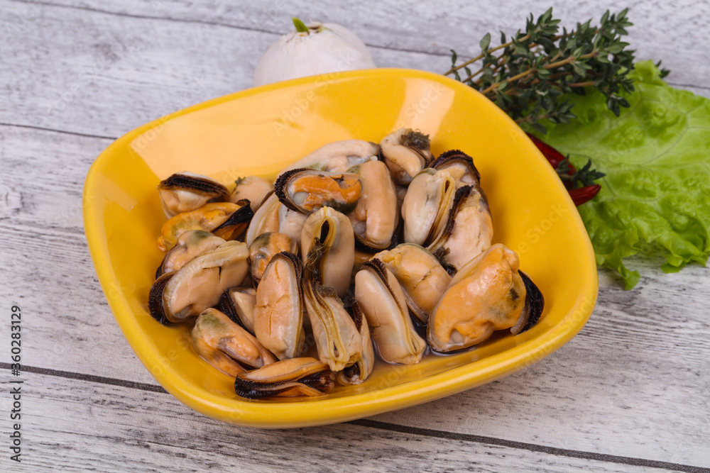 Pickled mussels in the bowl served pepper, garlic and salad Pickled mussels in the bowl served pepper, garlic and salad