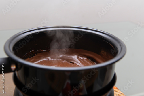 Close up of black fondue pan with chocolate.