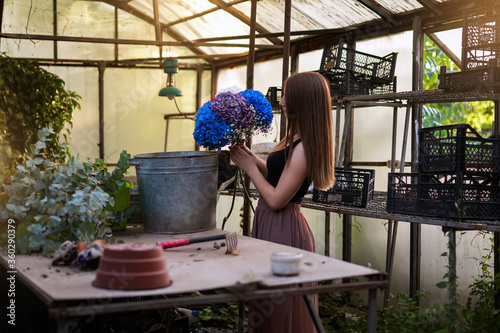 florist girl prepares a bouquet of hydrangeas in a beautiful garden