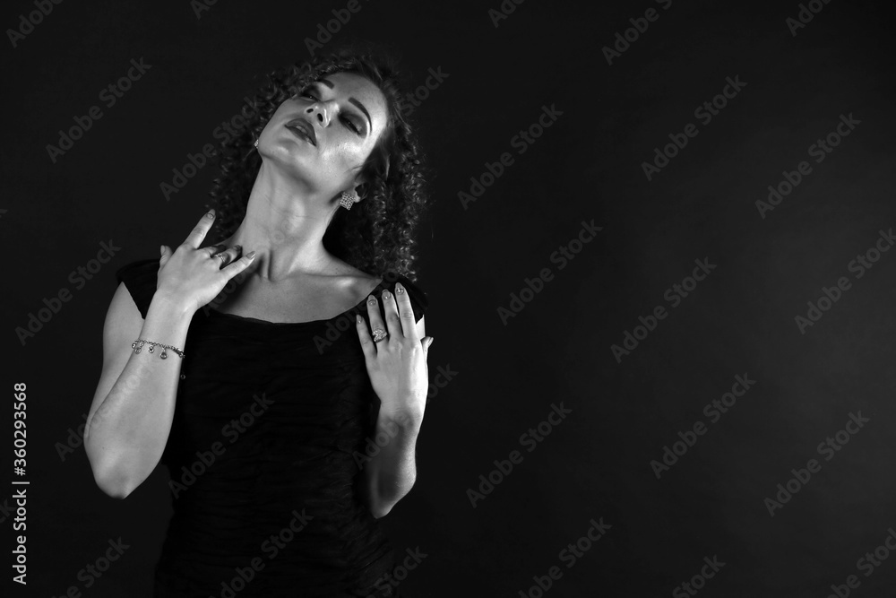 Black and white portrait of a cute curly girl in a black dress Black and white portrait of a cute curly girl in a black dress