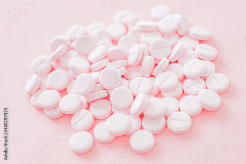 Pink pills on a pink background. Medical pharmacy concept