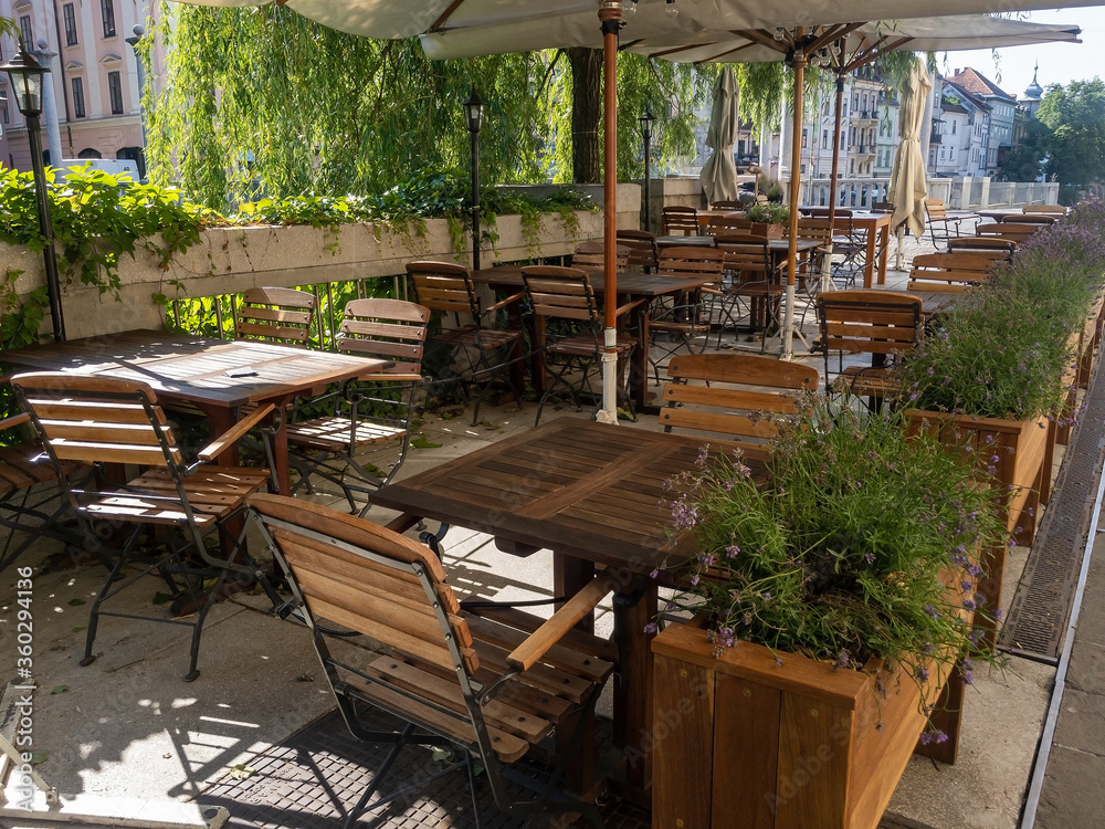 Fototapeta premium A cozy outdoor cafe in the green trees on the riverbank