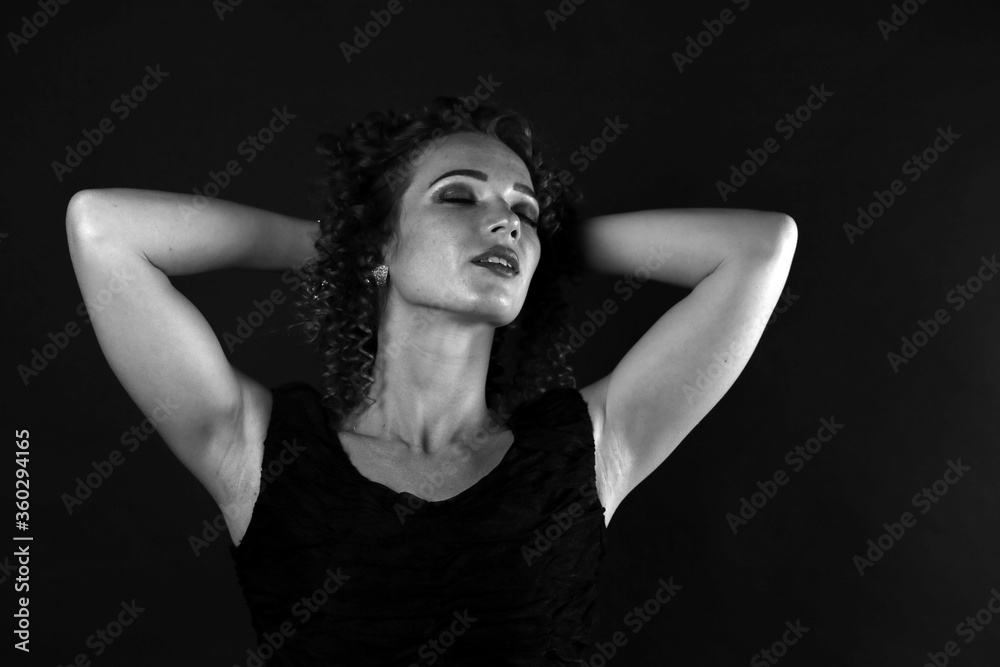 Black and white portrait of a cute curly girl in a black dress Black and white portrait of a cute curly girl in a black dress