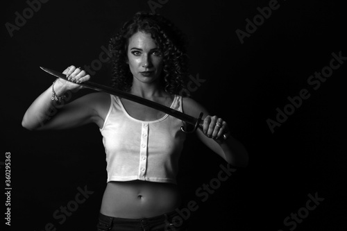 Black-white portrait of a curly girl with a bayonet-knife