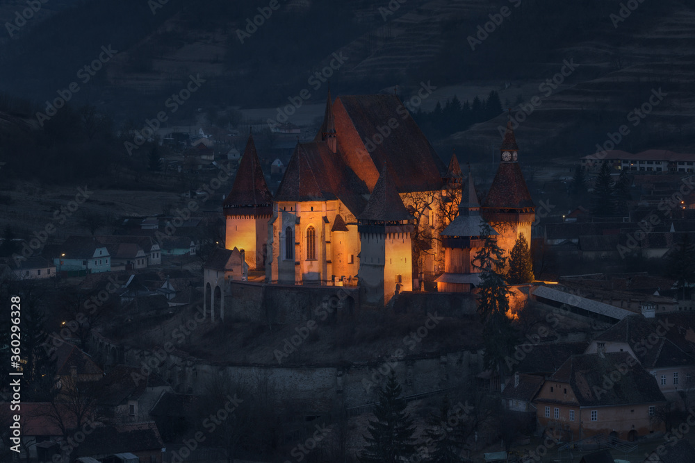 Morning In Biertan, Old Transylvania,One Of Most Famous Four Ancient Fortification Churches Of Romania.Blue Hour.Pastel-Coloured Houses With Dilapidated Tiled Roofs Surround The Citadel.