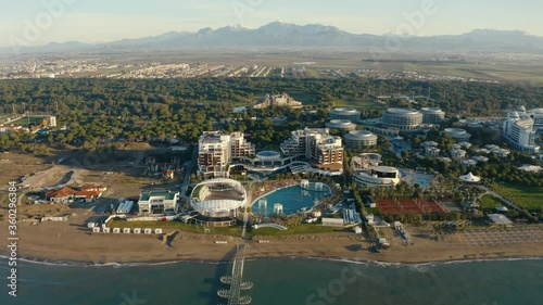Big area of a luxury resort along beautiful sea shore. Mountains in the background. Drone footage 4K