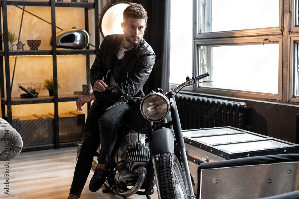 Stylish young man in leather jacket sitting on motorbike. Stock Photo ...