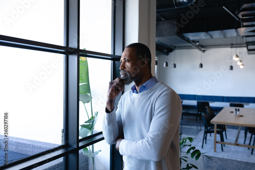 African American man looking outside and thoughtful