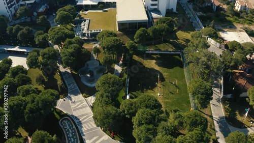Flying over a green zone with sport courts.People playing soccer in summer time